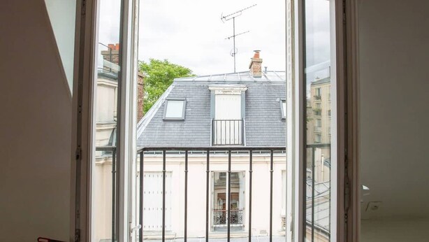 An open window with a view of a residential building and a balcony. - A Cozy Refuge - 18th - Mobility Lease (Paris)