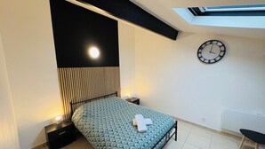 A bedroom with a bed, bedside tables, a clock, and a skylight. - Superb 6-person 80m2 apartment in Agde (Agde)