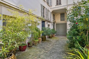 A narrow cobblestone alley with potted plants lining the sides. - Luxury Studio in Paris - S Vres - Mobility Lease (Paris)