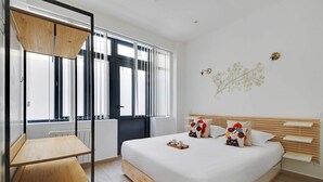 A modern bedroom with a wooden bed, a small table, and a window with blinds. - Amazing Apartment - 2BR 6P - Bastille (Paris)