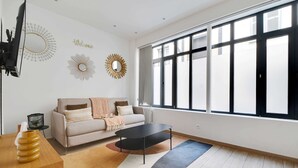 A modern living room with a sofa, coffee table, and decorative wall art. - Amazing Apartment - 2BR 6P - Bastille (Paris)