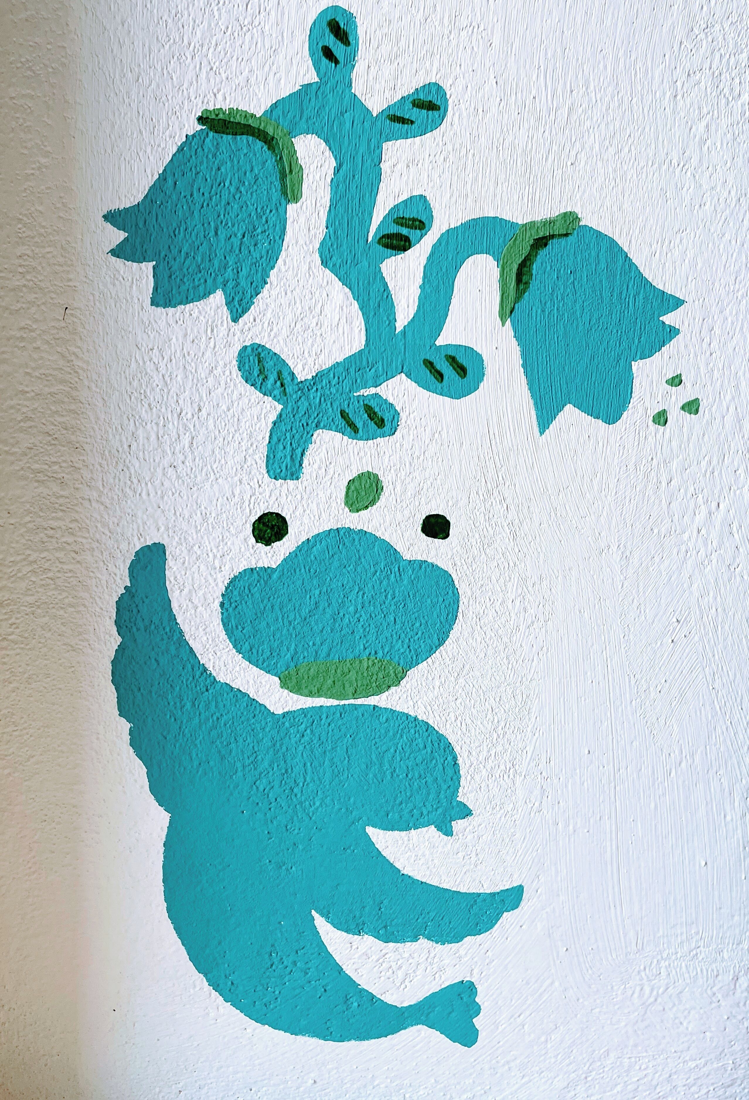 Un mur orné d’une fresque représentant une grenouille stylisée.