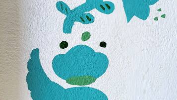 Un mur orné d’une fresque représentant une grenouille stylisée.