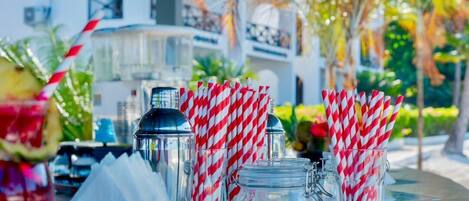 A table with clear glass mugs, a metal shaker, and a glass with a straw.