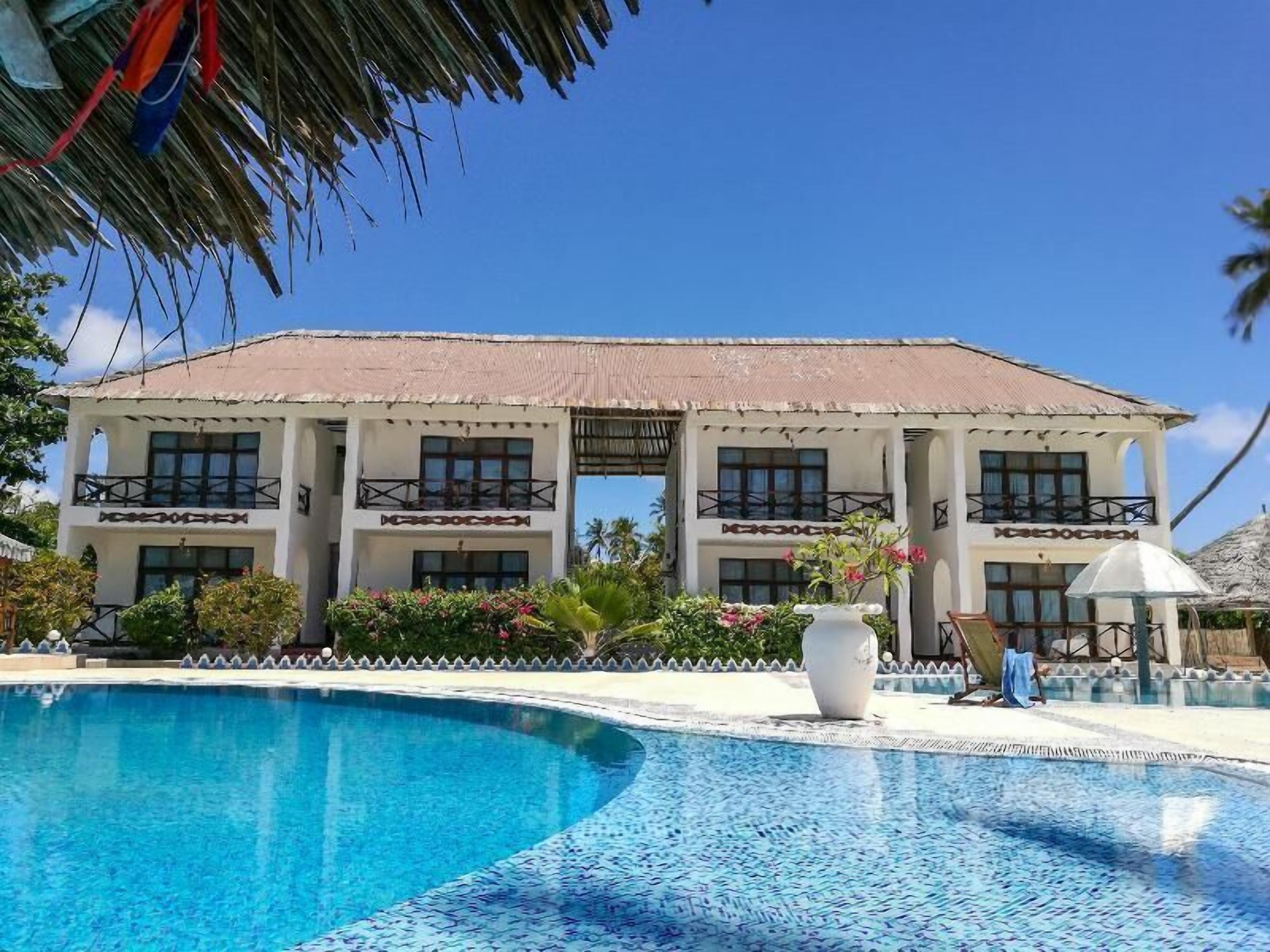 Un bâtiment à deux étages avec une piscine devant.