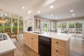 A spacious kitchen with a large island, built-in cabinetry, and a dishwasher.
