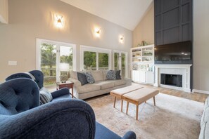 A living room with a sofa, a coffee table, a fireplace, and a TV.