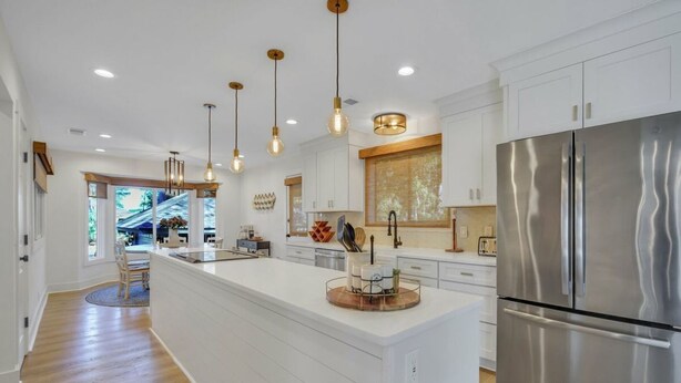A modern kitchen with a large island, stainless steel appliances, pendant lighting, and a view to the dining area. - Chic Hilton Head Getaway in Heart of Sea Pines (Hilton Head Island)