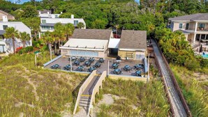 A coastal property with a parking area, a covered outdoor seating area, and a view of the surrounding landscape.