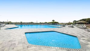 A swimming pool with multiple lanes, lounge chairs, and a clear sky. - Coastal Getaway | Ocean Views & Resort Amenities (Hilton Head Island)
