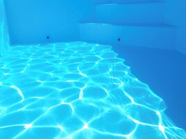 A clear blue pool with geometric patterns on the floor.