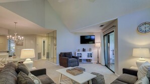 Een moderne woonkamer met een bank, voetenbankje en een televisie.
