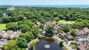 Vista aérea de una zona residencial con casas, un campo de golf y un estanque.