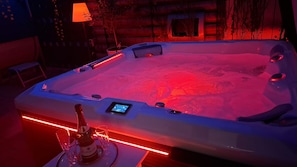 Un jacuzzi con panel de control digital, en un ambiente iluminado con luces rojas.