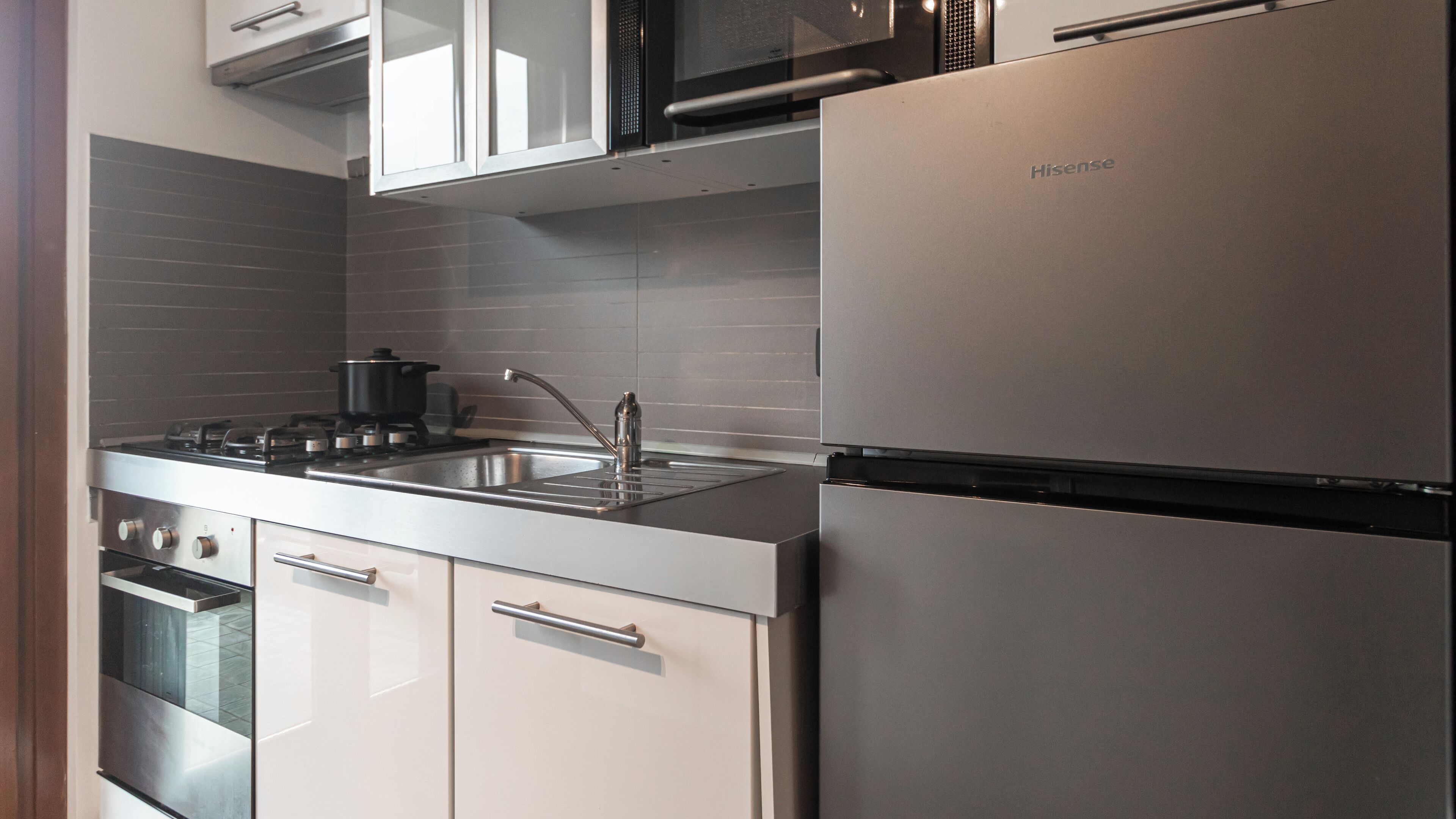 Une cuisine moderne équipée d’appareils électroménagers en acier inoxydable, notamment une cuisinière, un four et un réfrigérateur.