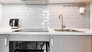 Una cucina moderna con piastrelle bianche a metro, elettrodomestici in acciaio inossidabile e un pannello di controllo digitale per il forno.
