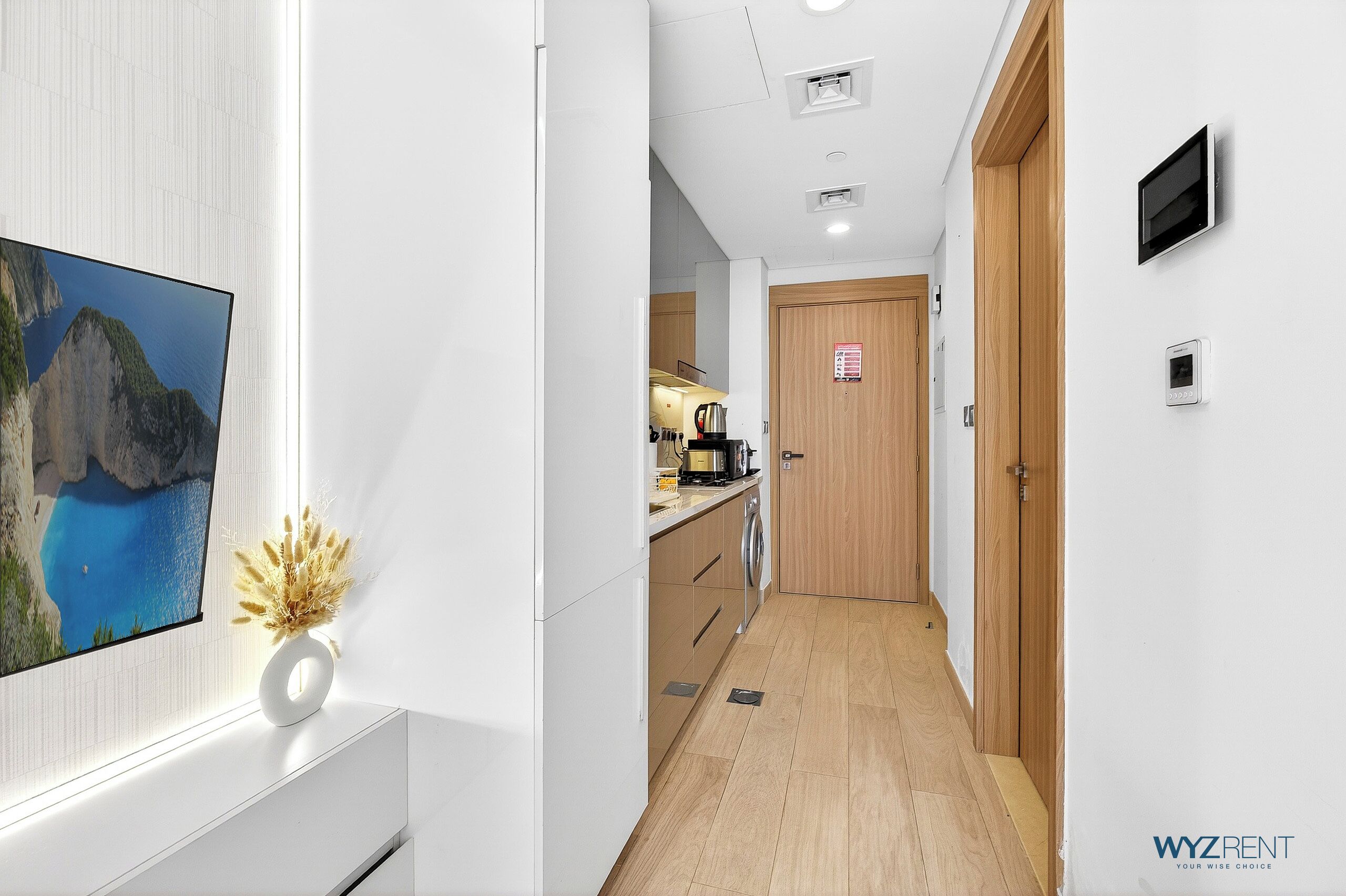A modern kitchen with a wooden countertop, a built-in oven, and a coffee machine.