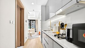 Cozinha moderna com micro-ondas, torradeira e utensílios sobre a bancada.