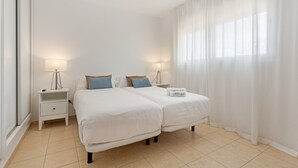Ein Schlafzimmer mit zwei Betten, einem Nachttisch, einer Lampe und einem Schild am Bett.