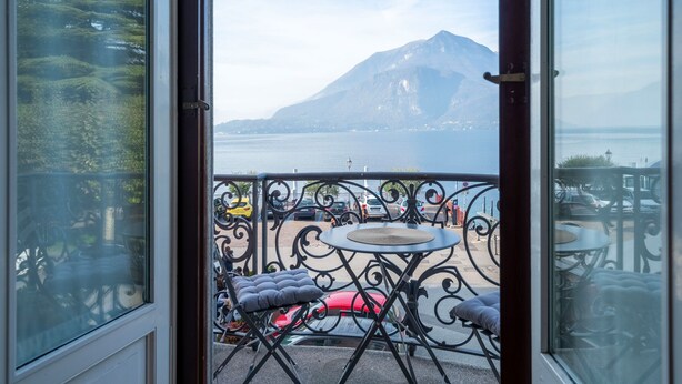 Un balcon avec vue sur une montagne et un plan d’eau.