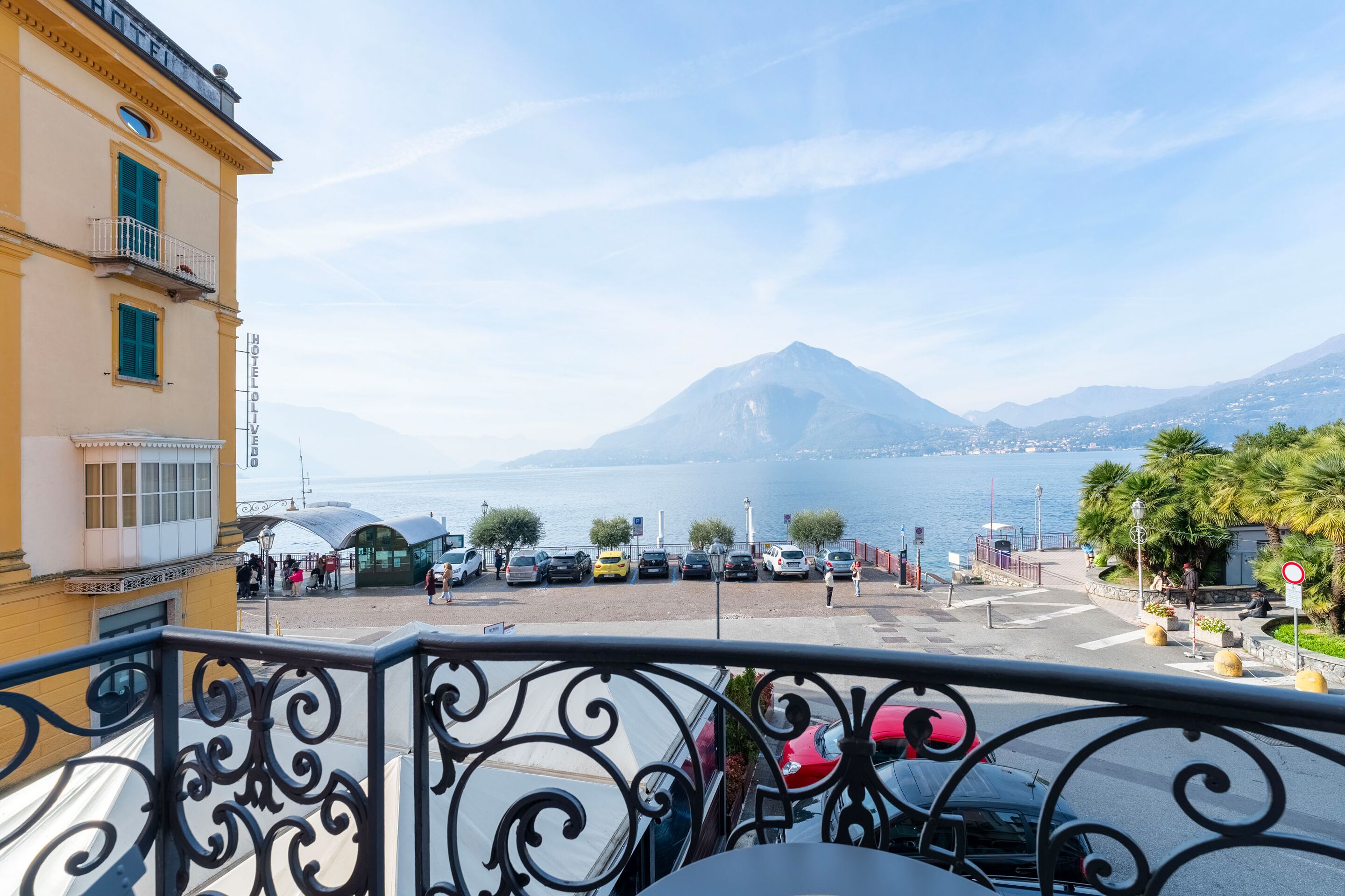 A hotel balcony with a view of a mountain and the sea.