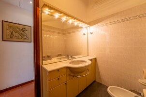 Un baño con dos lavabos, un espejo con iluminación y un inodoro.