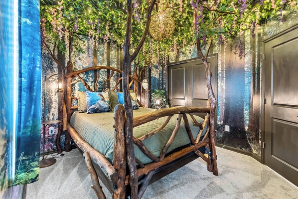 A bed with a wooden frame and green bedding, surrounded by a forest-themed mural with hanging vines and trees. - 7BR house with private pool and game room (Clermont)