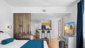 Une chambre d’hôtel moderne équipée d’un lit, d’un bureau et d’une kitchenette.