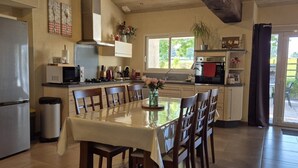 Une cuisine équipée d’une table à manger, de chaises, d’un réfrigérateur, d’un four à micro-ondes, d’une cuisinière et d’un évier.