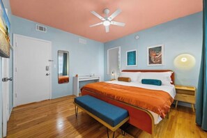 A bedroom with a bed, a bench, a ceiling fan, a desk, and a mirror. - #05 Corner Unit in Mid-century Art-Déco Building KingBed EnSuiteBath Steps>Beach (Miami Beach)