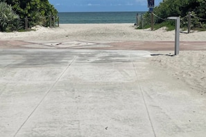 A paved pathway leading to a beach with a clear view of the ocean. - #05 Corner Unit in Mid-century Art-Déco Building KingBed EnSuiteBath Steps>Beach (Miami Beach)