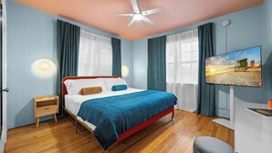 A neatly arranged bedroom with a bed, bedside table, and a TV on the wall. - #07 Corner Unit in Mid-century Art-Déco building KingBed EnSuiteBath PetsOK (Miami Beach)