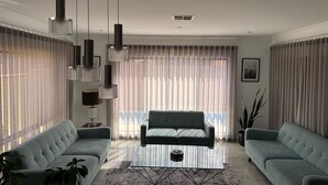 Un salon moderne avec un canapé, une table basse et des luminaires suspendus.