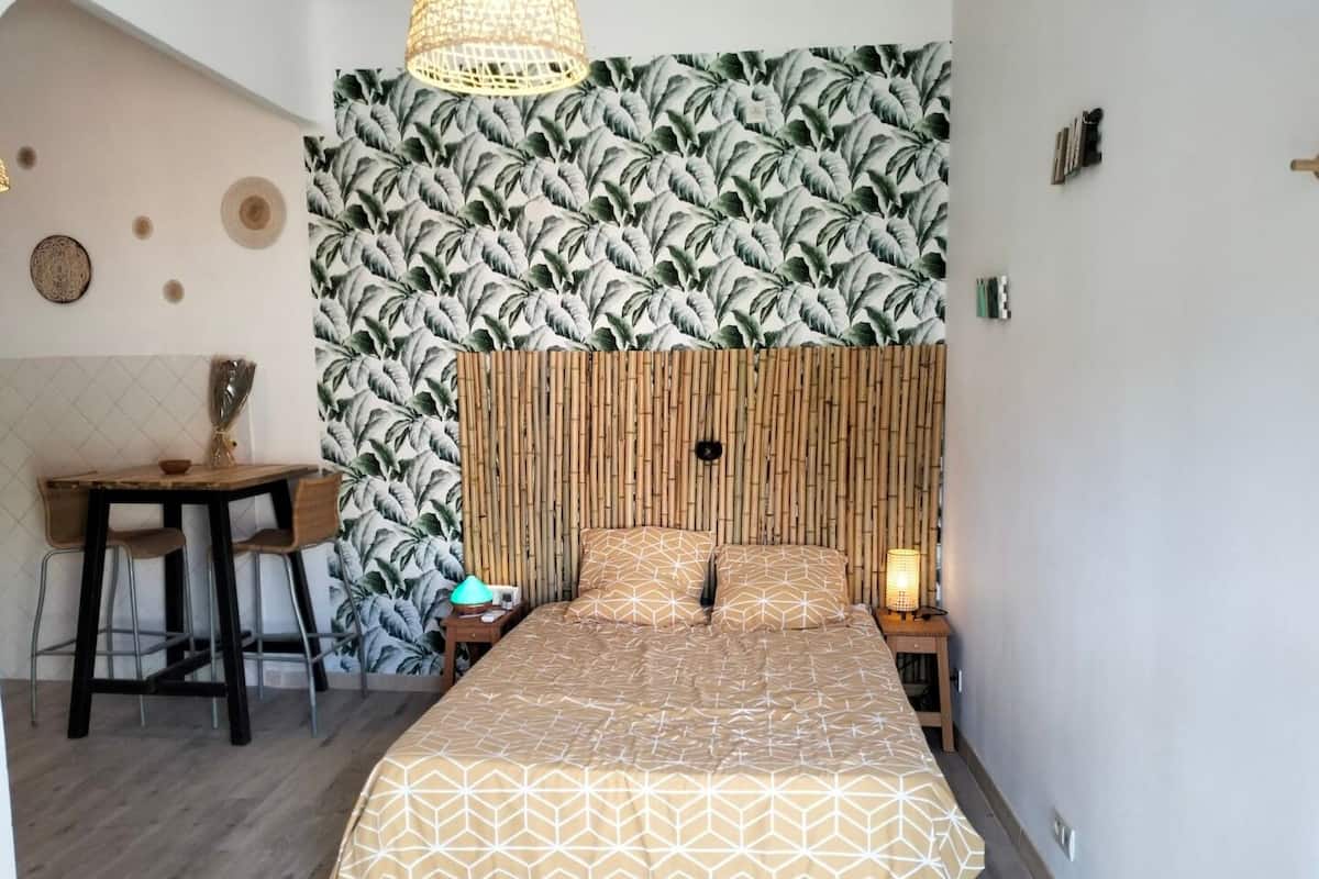 A bedroom with a bed, a desk, and a chair.