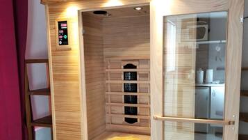 Eine Holzsauna mit Bedienfeld, Ablagen und einem gelben Handtuch.