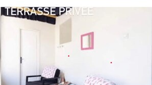 A private terrace with two black chairs, a small table, and a pink-framed mirror on the wall. - Loveroom Toulon (Toulon)