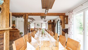 A long wooden dining table set for a meal, with chairs on both sides. - Apartment 'Rebblick' with Shared Terrace, Shared Garden and Wi-Fi (Oberkirch)