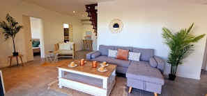 A modern living room with a sofa, coffee table, and a potted plant.