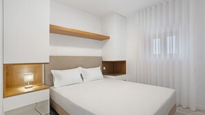A modern bedroom with a bed, bedside tables, and a headboard.