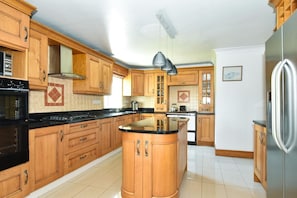 A kitchen with wooden cabinets, a central island, and stainless steel appliances.