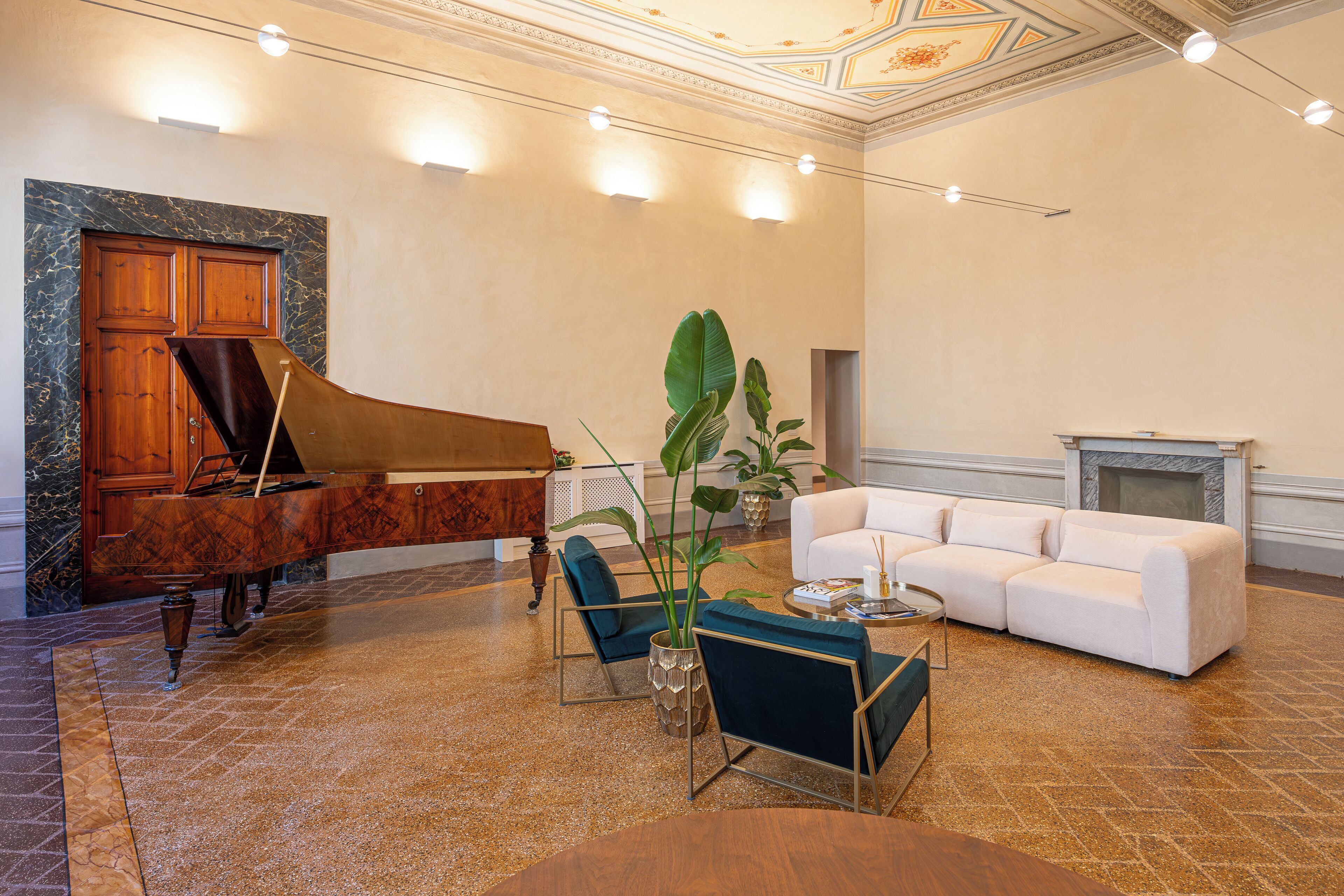 A spacious living room with a grand piano, a white sofa, and a coffee table.