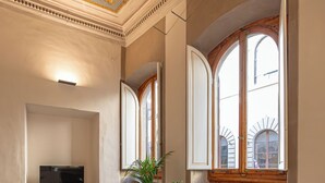 A kitchen with a stainless steel sink, a microwave, and a window with wooden shutters. - Maggio Living (Florence)