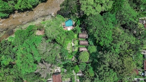 A house surrounded by dense green foliage, a small swimming pool, and three cylindrical structures. - Jungle River Villa for 10 |Pool, ATV, Tubing| Ubud (Sukawati)