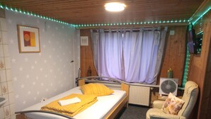 A room with a bed, a chair, a radiator, and a fan. - Small Studio in Countryside *Simple and Affordable (Buchholz in der Nordheide)