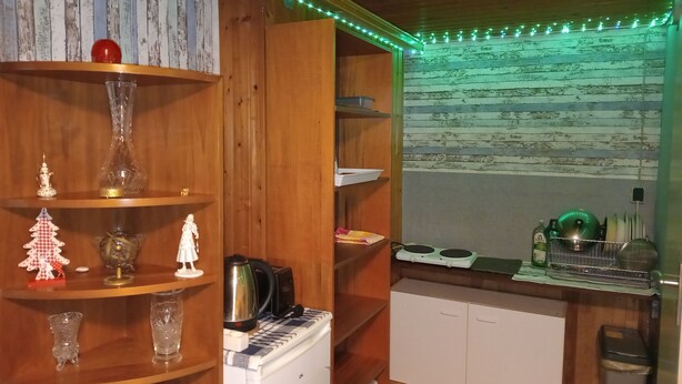 A compact kitchen with wooden cabinets, a small refrigerator, and a sink area. - Small Studio in Countryside *Simple and Affordable (Buchholz in der Nordheide)