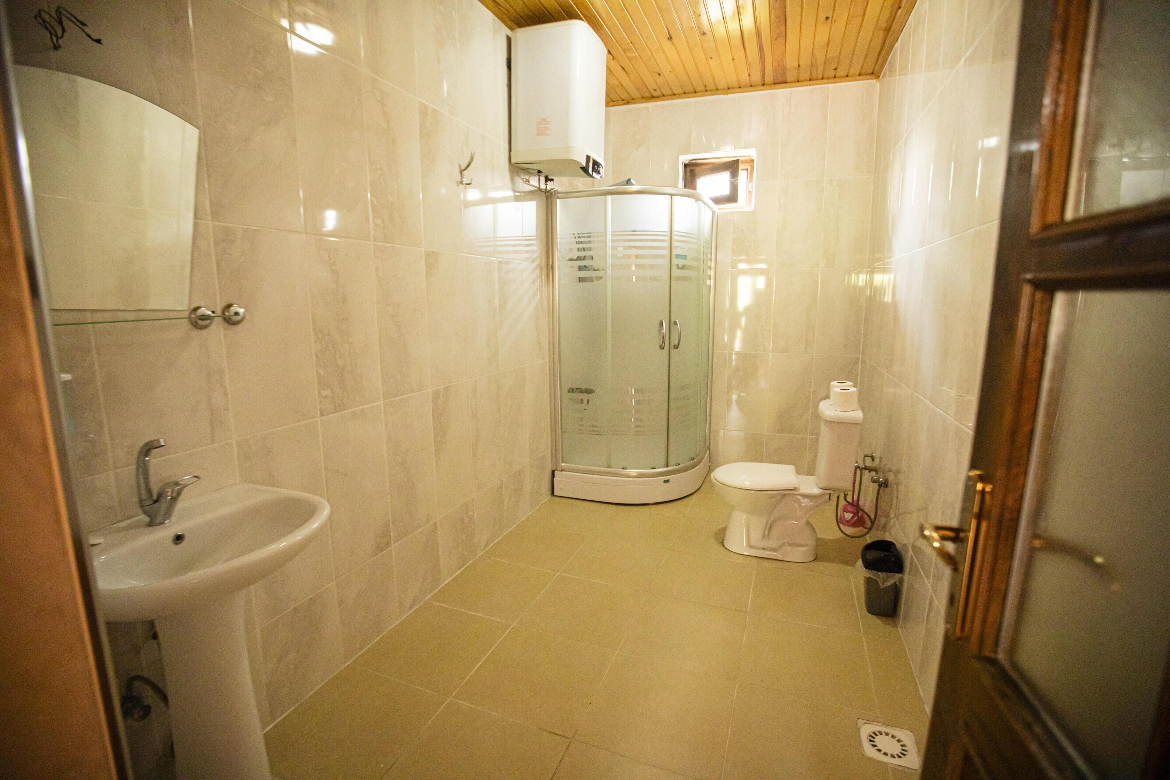 Un baño con lavamanos, inodoro y cabina de ducha de vidrio.