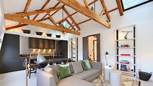 A modern living room with a grey sofa, a patterned rug, and a wooden ceiling structure. - Super premium - Cadogan Square 3 bedroom apartment (London)