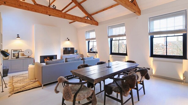 A spacious living room with a wooden ceiling, a grey sofa, a dining table with chairs, and a fireplace. - Super premium - Cadogan Square 3 bedroom apartment (London)