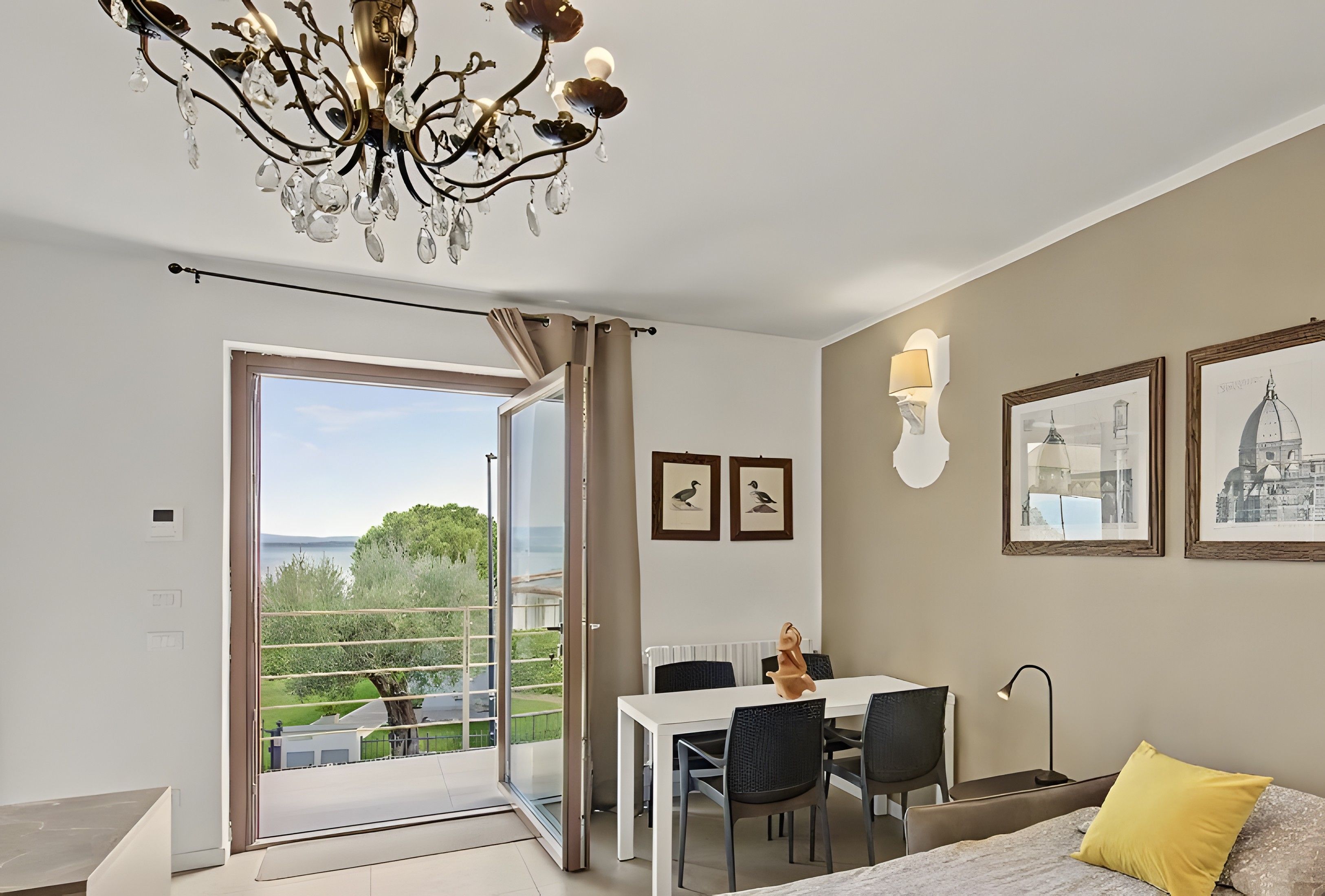 Un dormitorio moderno con balcón, zona de comedor y vista al mar.