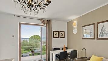 Un dormitorio moderno con balcón, zona de comedor y vista al mar.